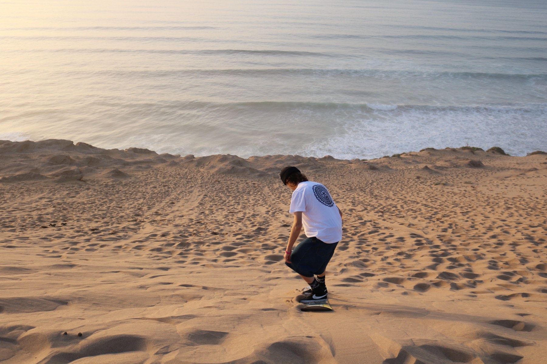 Sandboarding above the Atlantic in warm evening light
